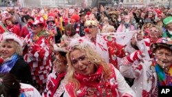 Thousands of revelers celebrate the start of the carnival season in the streets of Cologne, Germany, Nov. 11, 2021, despite a surge in COVID-19 cases in the country.