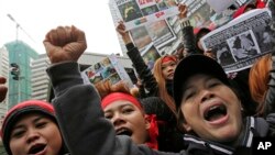 Pembantu rumah tangga dan pendukungnya meneriakkan slogan sambil memegang foto TKW berusia 23 tahun Erwiana Sulistyaningsih. PRT bersama masyarakat sipil lainnya akan menggelar aksi menuntut pengesahan RUU PRT. (Foto: AP)