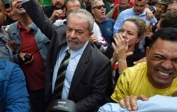 Former Brazilian President Luiz Inacio Lula da Silva, center left, is greeted by supporters as he arrives to the Federal Justice building in Curitiba, Brazil, May 10 2017.