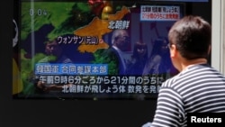 Seorang pria di sebuah jalan di Tokyo menonton siaran televisi tentang berita Korea Utara menembakan rentetan rudal dari pantai timur, 4 Mei 2019.