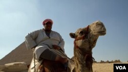 FILE - A man sits on his camel in front of the Pyramids at Giza, Egypt, July 13, 2013. (A. Arabasadi/VOA) 