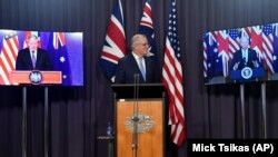 Le 1er ministre australien Scott Morrison en liaison vidéo avec le Premier ministre britannique Boris Johnson (à g) et le président américain Joe Biden lors d'une conférence de presse conjointe au Parlement de Canberra, Australie, le 16 septembre 2021.(Ph AP/Mick Tsikas)