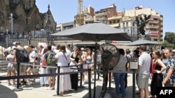 FILE - Tourist line up to enter at the Sagrada Familia basilica in Barcelona on July 18, 2023. (Photo by Pau BARRENA / AFP)