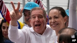 Edmundo González Urrutia, candidato presidencial opositor, hace el signo de victoria junto a la dirigente María Corina Machado durante un acto de campaña en Aragua, el 18 de mayo de 2024.