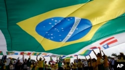 FILE - Members of the media record as a vehicle belonging to the Brazilian Federal Revenue Authority (RFP) leave the headquarters of Brazilian conglomerate Camargo Correa during "Operation Car Wash" in Sao Paulo, Nov. 14, 2014. 