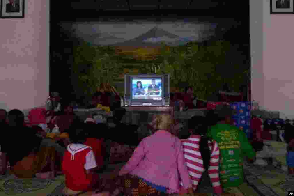 Evacuees gather to watch television to stave off boredom at the Wonokerto evacuation shelter (VOA Photo S. Schonhardt)