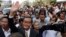 Sam Rainsy, front center, the head of the main opposition Cambodia National Rescue Party (CNRP) waves to the crowd before entering Phnom Penh Municipality Court in Phnom Penh, Cambodia, Tuesday, Jan. 14, 2014. Sam Rainsy and his party's Deputy President Kem Sokha appeared for questioning at the court about their possible involvement in inciting violence and social unrest, after four garment workers were brutality shot dead by government armed forces, on Jan. 3, according to a CNRP lawmaker. (AP Photo/Heng Sinith)