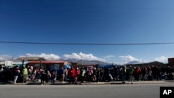 Migrantes venezolanos hacen fila para ser procesados ​​después de cruzar a Chile desde la frontera con Bolivia, cerca de Colchane, Chile, el 6 de febrero de 2021. Foto: AP.