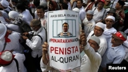 Seorang pengunjuk rasa mengacungkan poster dalam demonstrasi menuntut agar Gubernur Basuki Tjahaya Purnama atau Ahok ditangkap karena dinilai menista agama Islam, di Jakarta, 2 Desember 2016. 