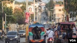 Tap Tap mwayen transpòtasyon ki pi kouran ann Ayiti. 2 tap tap kap desann sou oto wout Delmas. Foto: Arthur Jean Pierre/ VOA, 18 fevriye 2019, Delmas, Ayiti. 