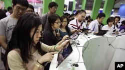 Visitors test new tablets at the Computex computer expo in Taipei,Taiwan, June 2, 2011.