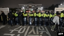 La police monte la garde devant la porte principale de l'Assemblée nationale à Séoul, en Corée du Sud, le 3 décembre 2024, après que le président Yoon Suk Yeol a déclaré la loi martiale d'urgence. 