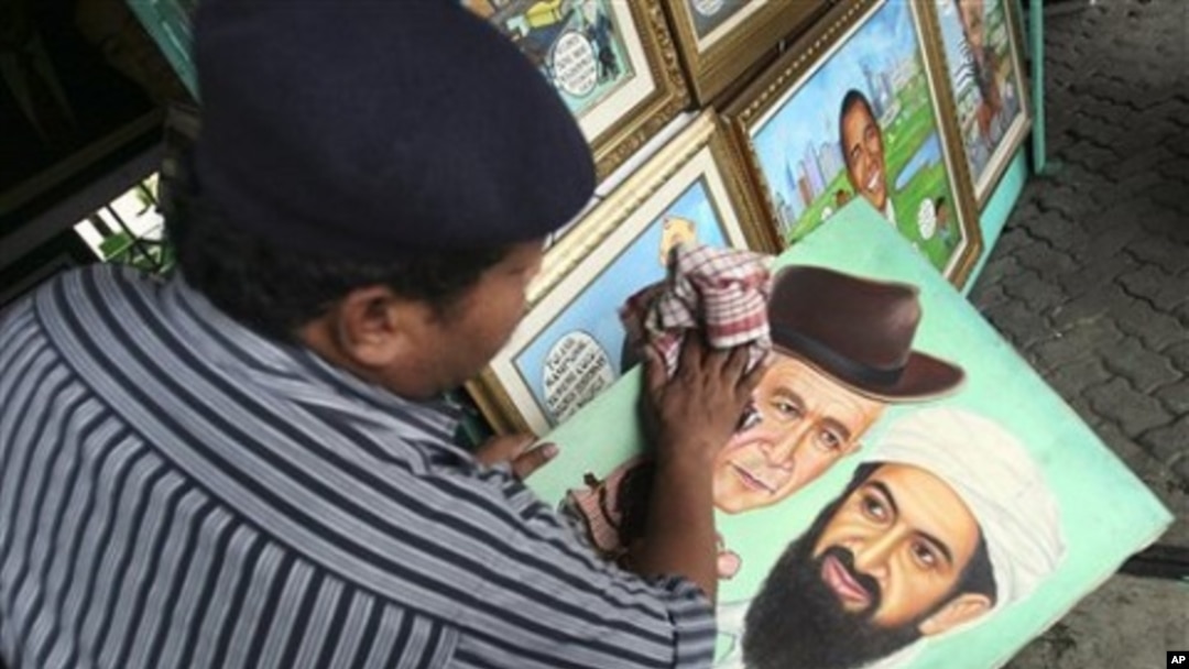 Indonesian painter S. Wito wipes his painting of Osama bin Laden and former U.S. President George Bush at his street-side studio in Jakarta, Indonesia, May 2, 2011.