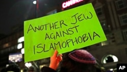 Elliya Cutler, of Somerville, Massachusetts, holds a sign during a protest of President Trump's revised travel ban by several hundred people organized by the Harvard Islamic Society near the campus of Harvard University in Cambridge, Massachusetts, March 7, 2017.