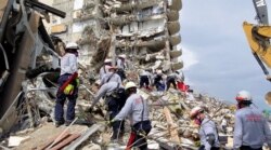Search and rescue personnel look for survivors in the rubble at the Champlain Towers South Condo in Surfside, Fla., section of Miami, June 25, 2021, in this photo provided by Miami-Dade Fire Rescue.
