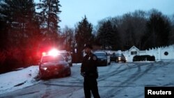Autos de la policía resguardan la casa del expresidente Bill Clinton y de la excandidata presidencial demócrata Hillary Clinton en Chappaqua, N.Y. después que los bomberos fueron llamados para apagar un incendio. Enero 3 de 2017.