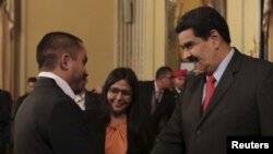 President Nicolas Maduro (R) and Venezuela's new Minister for Economy and Productivity, Luis Salas, shake hands Jan. 6, 2016, at a meeting at Miraflores Palace in Caracas.