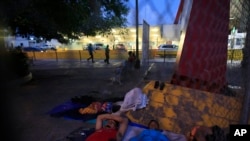 A small group of migrants waiting to seek asylum sleeps at the entrance to the Puerta Mexico international bridge in Matamoros, Mexico, June 28, 2019. 