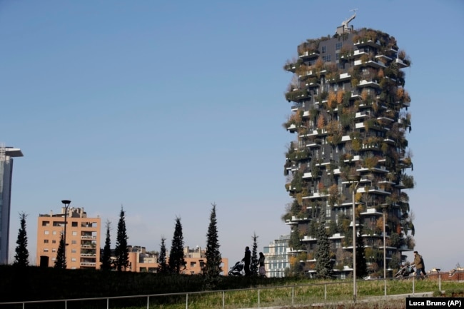 People walk through the Tree Library park in Milan, Italy, Sunday, Dec. 9, 2018. (AP Photo/Luca Bruno)