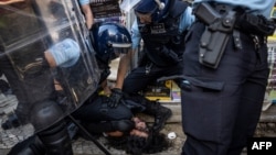 Portuguese police detain a woman who was protesting against the demonstration against "uncontrolled immigration" called by Portuguese far-right party Chega in Lisbon, Sept. 29, 2024. 