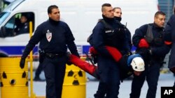 French police officers arrest a member of the group Greenpeace who was hanging a banner on the building of the energy giant EDF during a nuclear protest in Paris, Dec. 14, 2016.