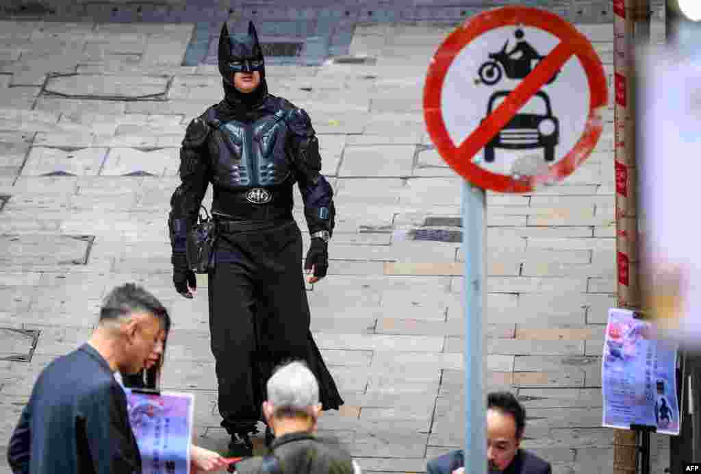 A man dressed as Batman walks on a street in Hong Kong.