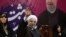 Iranian President Hassan Rouhani, center, waves to his supporters as he is accompanied by Vice President for Women and Family Affairs Shahindokht Molaverdi in a campaign rally for the May 19 presidential election in Tehran, Iran, May 9, 2017. 