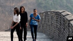 Ibu Negara AS Michelle Obama bersama putri-putrinya Malia dan Sasha dalam kunjungan ke China, Maret 2014.