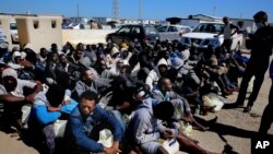 FILE - African illegal migrants wait to receive medial assistance after being rescued by coast guards, in Tripoli, Libya, April 11, 2016. 