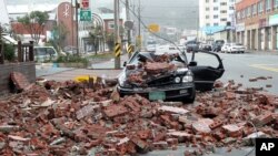 A vehicle damaged by fallen bricks from a building as Typhoon Bolaven brings heavy downpours and winds to Wando, South Korea, August 28, 2012.