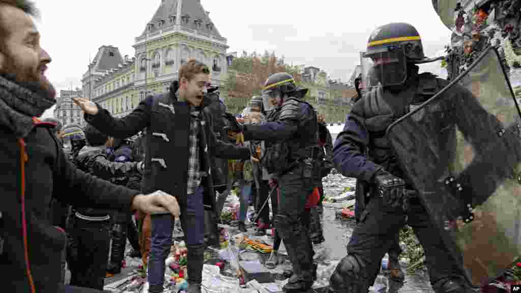 Des policiers se battent avec les militants qui manifestent en marge de la Conférence sur le climat de Paris, à la place de la République, sur les bougies et des fleurs déposées en hommage des victimes des attentats de Paris, 29 novembre 2015.&nbsp;