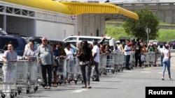 Warga antre untuk membeli barang kebutuhan sehari-hari menjelang kebijakan lockdown di Johannesburg, Afrika Selatan (24/3). 