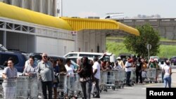 Shoppers queue to stock up on groceries at a Makro Store at Strubens Valley, ahead of a nationwide lockdown for 21 days to try to contain the coronavirus disease outbreak, in Johannesburg, South Africa, March 24, 2020. 