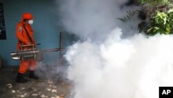 ARCHIVO - Un trabajador fumiga el patio de una casa para controlar la propagación de enfermedades transmitidas por mosquitos, el 4 de julio de 2024, en Los Santos, un vecindario en Soyapango, El Salvador.