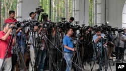 FILE - Reporters cover proceedings outside a court in Dhaka, Bangladesh, May 3, 2016. A Bangladeshi journalists group is expressing outrage over the recent detention and one year sentence given to Bangla Tribune correspondent Ariful Islam. 