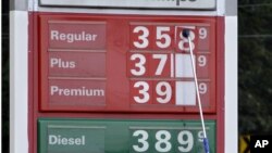 A man changes fuel prices at a ConocoPhillips gas station in Little Rock, Ark. The price of oil fell to its lowest point in nearly two months. U.S. consumer confidence slow, encouraging, Sept. 26, 2012