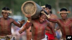 FILE - Kanela Indians carry a tree trunk during a race at the Indigenous Games in Cuiaba, Brazil, Nov. 13, 2013.