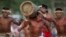 FILE - Kanela Indians carry a tree trunk during a race at the Indigenous Games in Cuiaba, Brazil, Nov. 13, 2013.