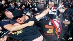 Un oficial lucha con un manifestante que quemaba una bandera, en las cercanías de la Quicken Loans Arena de Cleveland.