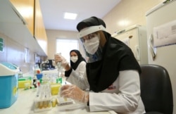 Iranian medical staff work on the production of COVID-19 test kits at a medical center in Karaj, in the northern Alborz Province, on April 11, 2020.