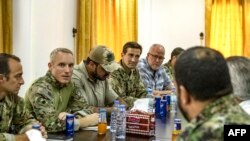 Members of the US-led coalition forces meet with local forces from the Tal Abyad military council in the northern Syrian town of Tal Abyad, on Sept. 15, 2019.