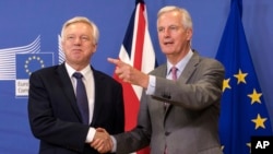 EU chief Brexit negotiator Michel Barnier, right, welcomes British Secretary of State David Davis for a meeting at the EU headquarters in Brussels, July 17, 2017.