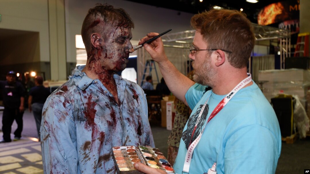 A zombie has his makeup done at AMC's "Walking Dead" booth before Preview Night at Comic-Con International, held at the San Diego Convention Center, July 8, 2015.
