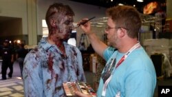 A zombie has his makeup done at AMC's "Walking Dead" booth before Preview Night at Comic-Con International, held at the San Diego Convention Center, July 8, 2015.