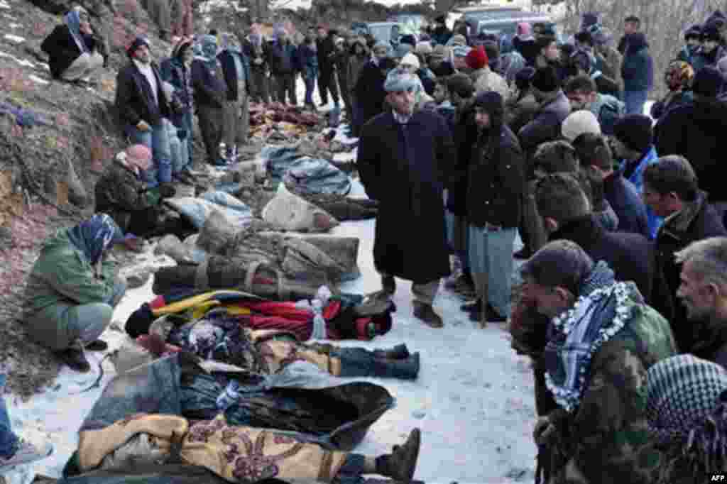 People look at bodies lying on the ground after Turkey's air force attacked suspected Kurdish rebel targets across the border in Iraq, killing at least 35 people, many of them believed to be smugglers mistaken for guerrillas, near the Turkish village of O