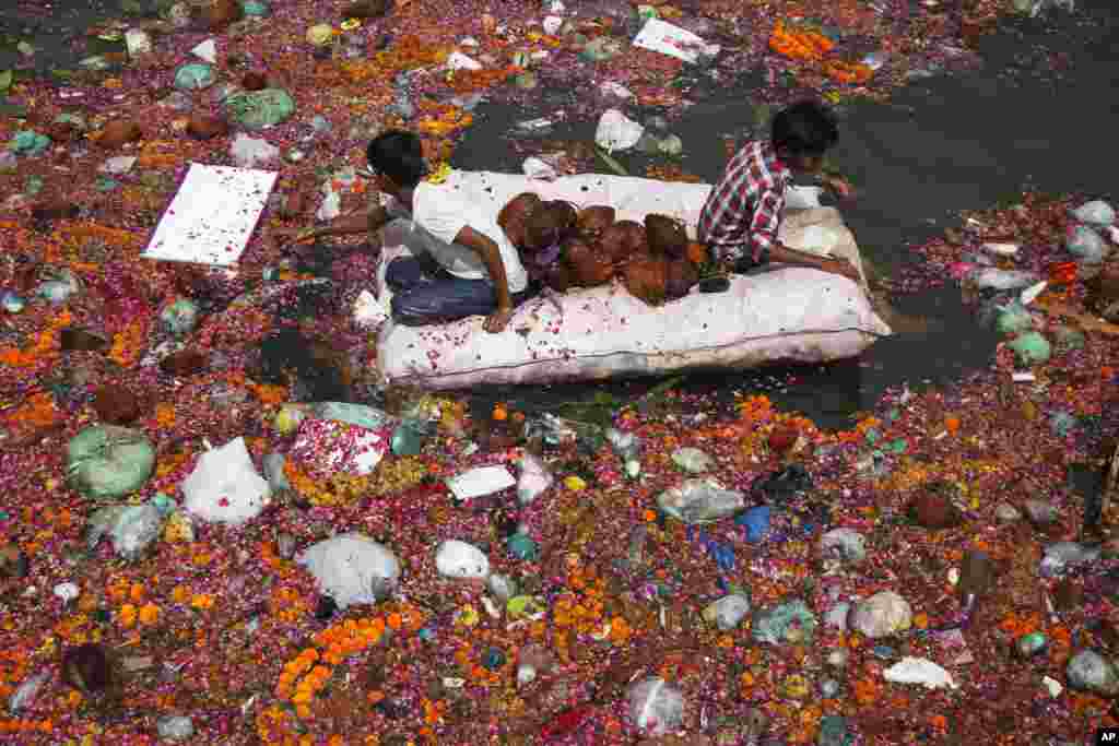 Indian children search for reusable items among offerings thrown by devotees in the river Sabarmati at the end of Dashama festival in Ahmadabad.