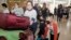 A woman and her children arrive in Sydney, Jan. 23, 2020, from a flight from Wuhan, China. China closed off the city of more than 11 million people in an effort to prevent the spread of a deadly virus that has spread to other cities and countries.