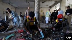 Petugas keamanan memeriksa lokasi ledakan di sebuah madrasah di Peshawar pada 27 Oktober 2020. (Foto: AFP)