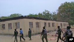 Les éléments des forces de sécurité devant l'école secondaire incendiée à Chibok, Nigeria, le 21 avril 2014.