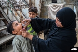 A health worker administers polio drops to a child during a door-to-door vaccination campaign in Karachi, Pakistan, Sept. 9, 2024.